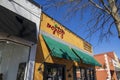 Red Hare Brewing and Distilling in an orange building with green awnings, tables and chairs on the sidewalk and people walking