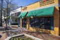 Red Hare Brewing and Distilling in an orange building with green awnings, tables and chairs on the sidewalk and people walking