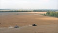 Red harvester machine drive on rural field - grain harvesting on a Sunny summer day, side view. Harvester on the field