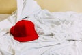 Red hat on the left side over white blanket on the bed with yellow background Royalty Free Stock Photo