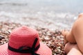 Red hat and woman`s legs on the by the sea. Sunbathing. Rest on the sea. Relaxing on the beach. Selective focus Royalty Free Stock Photo