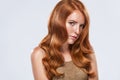 Red head girl with long and shiny wavy hair. Beautiful model woman with curly ginger hairstyle and frackles. Royalty Free Stock Photo