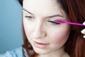 Red head woman brushing her extension eyelashes with a brush. girl with impending eyelid make-up mascara. Beauty
