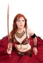 Red-headed belly dancer posing with sword Royalty Free Stock Photo