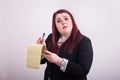 Red headed female wearing business suit taking notes on yellow notepad