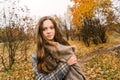 Red-headed freckled girl in autumn yellow park. The first snow, wet rain.