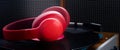 Red headphones lie on a turntable, against the background of old speakers, close-up Royalty Free Stock Photo