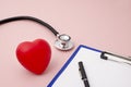 Red Heart Alongside Stethoscope and Clipboard with Pen Royalty Free Stock Photo