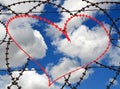 Red heart in barbwire on sky background