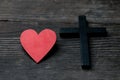 The red heart on black black background including cross beside the heart. The cross is the symbol of Christian religion. God love Royalty Free Stock Photo