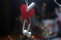 Red heart with white earphone hanging on dark bokeh light background. Blank paper notes on black background. Copy space. Royalty Free Stock Photo