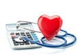 Red heart and calculator with stethoscope on white background Royalty Free Stock Photo