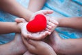 Red heart in child and parent hands with love and harmony