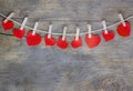 Red heart clamped with clips made of wood on brown wooden background. Royalty Free Stock Photo