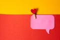 Red heart on a clothespin and a pink sticky note colorful background Royalty Free Stock Photo