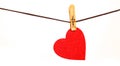 Red heart from dense fabric on a clothespeg on a rope