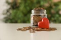 Red heart and donation jar with coins on table against blurred background Royalty Free Stock Photo