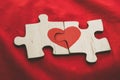 Red heart is drawn on the pieces of the wooden puzzle lying next to each other on red background. Love concept. St. Valentine day Royalty Free Stock Photo