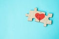 Red heart is drawn on the pieces of the wooden puzzle lying next to each other on blue background. Love concept. St. Valentine day Royalty Free Stock Photo