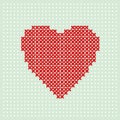 Red heart embroider by thread on turquoise background. Cross stitching on canvas.