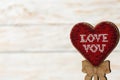 Red heart embroidered of beads on a wooden white background. The concept of Valentine`s Day. Royalty Free Stock Photo