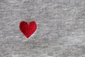 Red heart embroidered with threads on gray fabric background. Close-up, macro, copy space, flat lay. March 8, February 14, Royalty Free Stock Photo