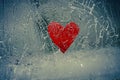 Red heart frozen in cracked ice.