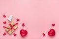 Red heart, gift box, white Cupid, candle on pink background