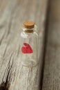 Red heart in the glass is closed. on a white rustic wooden table with space for text. Romantic love concept. Valentine`s Day greet Royalty Free Stock Photo