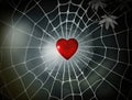 Red heart got caught in spider web on blurred dark background, captivity feeling of love concept