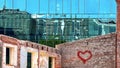 Building facade  Sun  Reflection graffiti love peace kiss red heart on wall ,modern  and old vintage house blue Windows  glass a Royalty Free Stock Photo