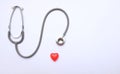 Copy space red heart and gray stethoscope isolate on white doctor table.concept health check and a doctor`s office