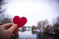 Red heart in the hand of the girl. river background Royalty Free Stock Photo