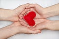 Red heart in the hands of a loving couple of man and woman on a white background. Valentine`s Day, creating a family, love Royalty Free Stock Photo