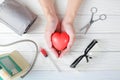 Red heart in hands with stethoscope medical instrument and injection, syringe on top. Royalty Free Stock Photo