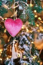 Red heart hanging as decorations on green Christmas tree, close-up Royalty Free Stock Photo