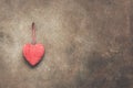 A red heart is hanging on a dark brown rustic wall. Valentine`s Day. Copy space. Toned