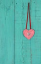 Red heart hanging by ribbon on teal blue wood background Royalty Free Stock Photo