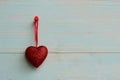 Red heart hanging on a thread on a blue wooden background Royalty Free Stock Photo