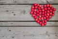 Red heart of hawthorn berries on a wooden background. Royalty Free Stock Photo