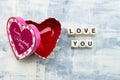 Red heart in a heart-shaped gift box. The inscription from wooden cubes LOVE YOU. Gift concept for Valentine`s day Royalty Free Stock Photo