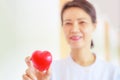 Red heart held by smiling female nurse`s hand, representing giving effort high quality service mind to patient. Professional, Spec