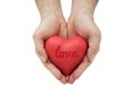 Red heart with imprinted love word in man`s hands.