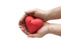 Red heart with imprinted love word in man`s hands.