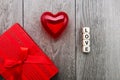 Red heart, inscription from wooden cubes LOVE and a gift in a box. concept for Valentine`s day Royalty Free Stock Photo