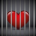 Red heart in a jail on dark background