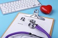 Red heart, keyboard and Medical stethoscope lying on cardiogram chart closeup. Medical help, prophylaxis, disease