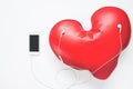 Red heart listening music from smartphone, Love concept on white