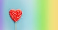 Red heart lollipop on rainbow background, love and Valentine day banner Royalty Free Stock Photo