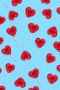 Red heart lollipops pattern on blue background